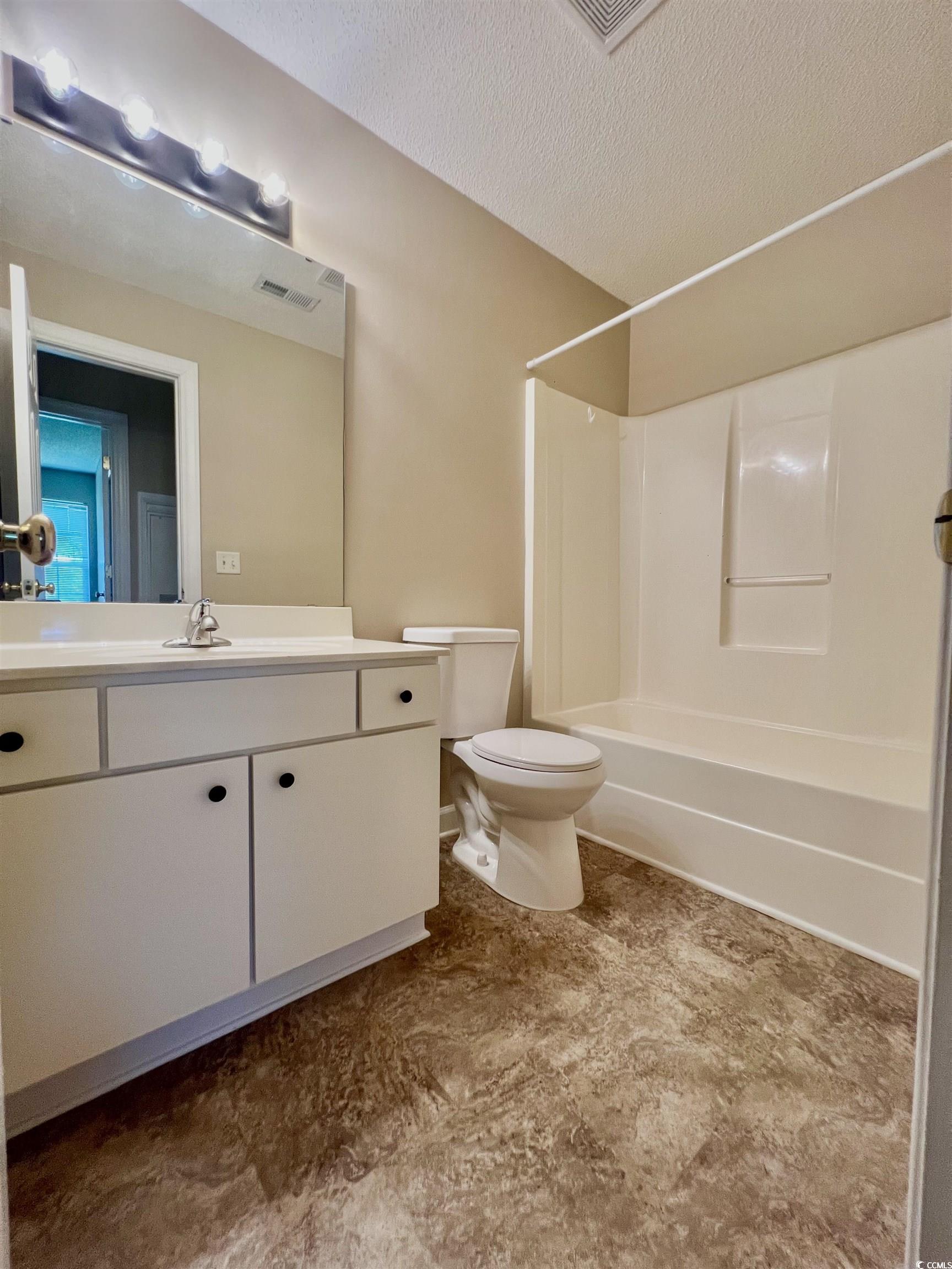 4394 Daphne Lane, Unit F Murrells Inlet, SC 29576 - Photo 29 of 40 Bathroom with toilet, vanity, a textured ceiling, and shower / tub combination
