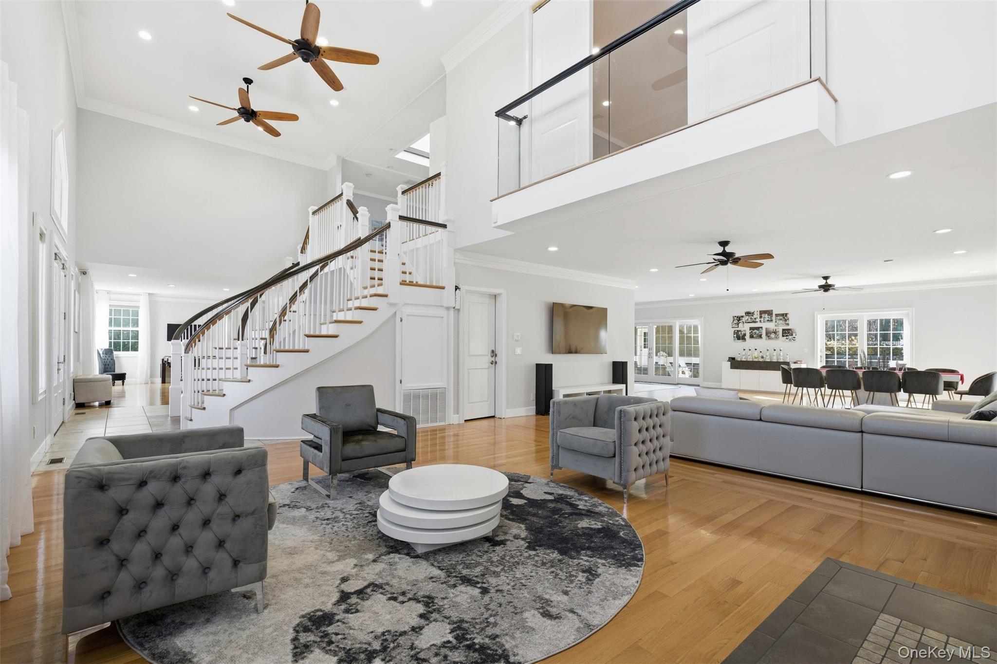 33 A Newtown Road Hampton Bays, NY 11946 - Photo 20 of 50 Living area featuring a ceiling fan, crown molding, plenty of natural light, light wood-style floors, and stairs