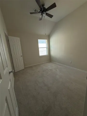 an empty room with a window and a fan