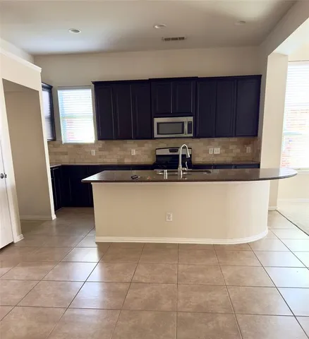 a kitchen with a sink a stove a microwave and cabinets