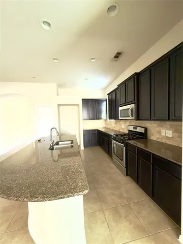 a kitchen with stainless steel appliances granite countertop a sink stove and refrigerator