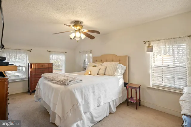 a spacious bedroom with a bed and a chandelier