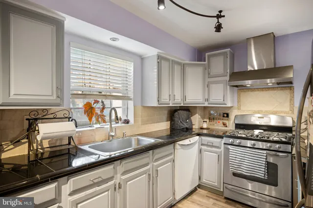 a kitchen with granite countertop a sink stainless steel appliances and cabinets