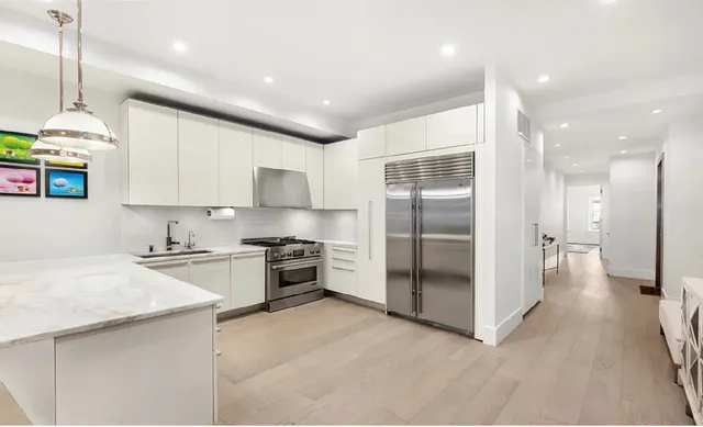 a living room with furniture a fireplace a rug and kitchen view
