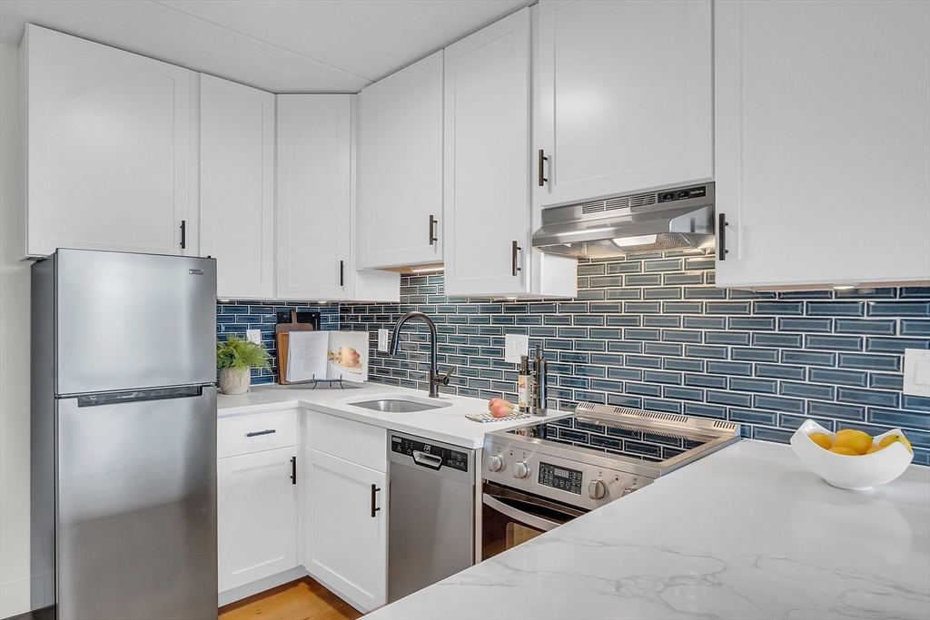 200 Swanton Street, Unit 502 Winchester, MA 01890 - Photo 3 of 24 a kitchen with stainless steel appliances a stove a sink and a refrigerator