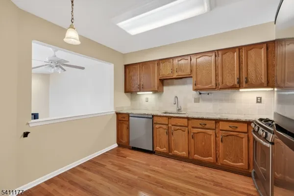 a kitchen with granite countertop wooden cabinets and white appliances