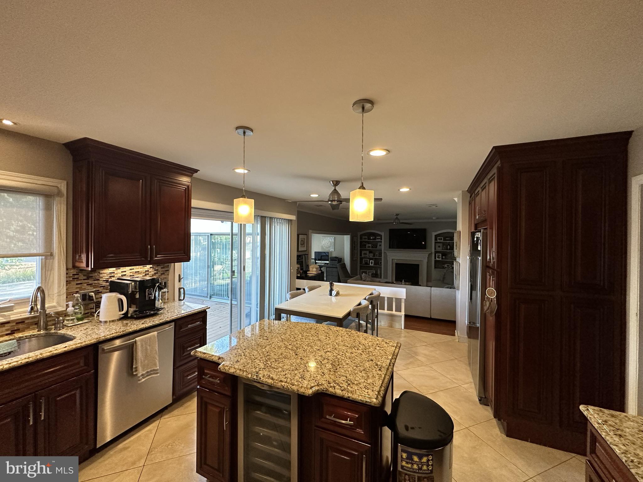 2269 Pine Road Huntingdon Valley, PA 19006 - Photo 26 of 61 a kitchen with kitchen island granite countertop wooden cabinets and a refrigerator