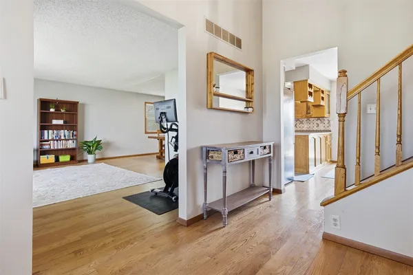 a view of a hallway with wooden floor and staircase