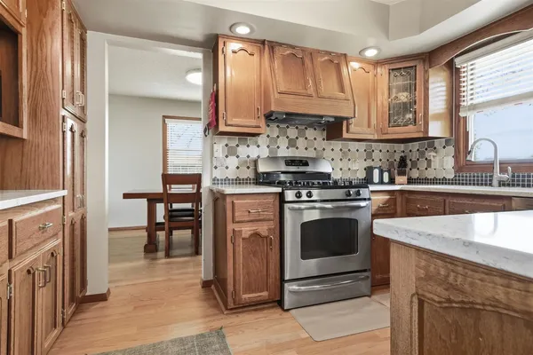 a kitchen with stainless steel appliances granite countertop a refrigerator and a stove top oven