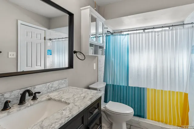 a bathroom with a granite countertop sink and a mirror