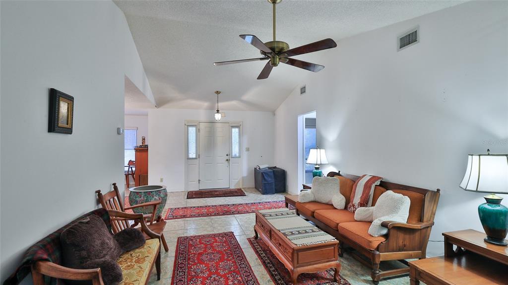 3085 Howland Boulevard Deltona, FL 32725 - Photo 7 of 14 a living room with furniture and a chandelier