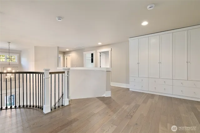 an empty room with wooden floor and mirror