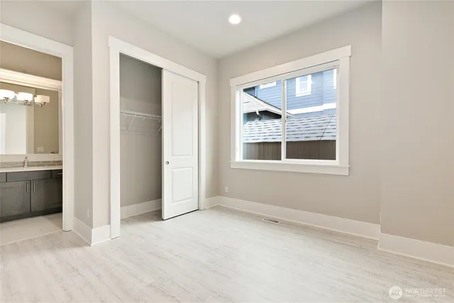an empty room with windows and cabinet