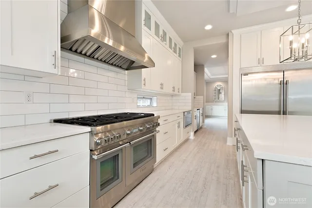 a kitchen with stainless steel appliances granite countertop a stove a refrigerator and a sink