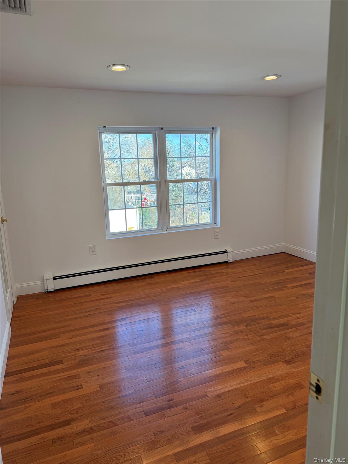 72 North Fordham Road Hicksville, NY 11801 - Photo 24 of 27 an empty room with wooden floor and windows