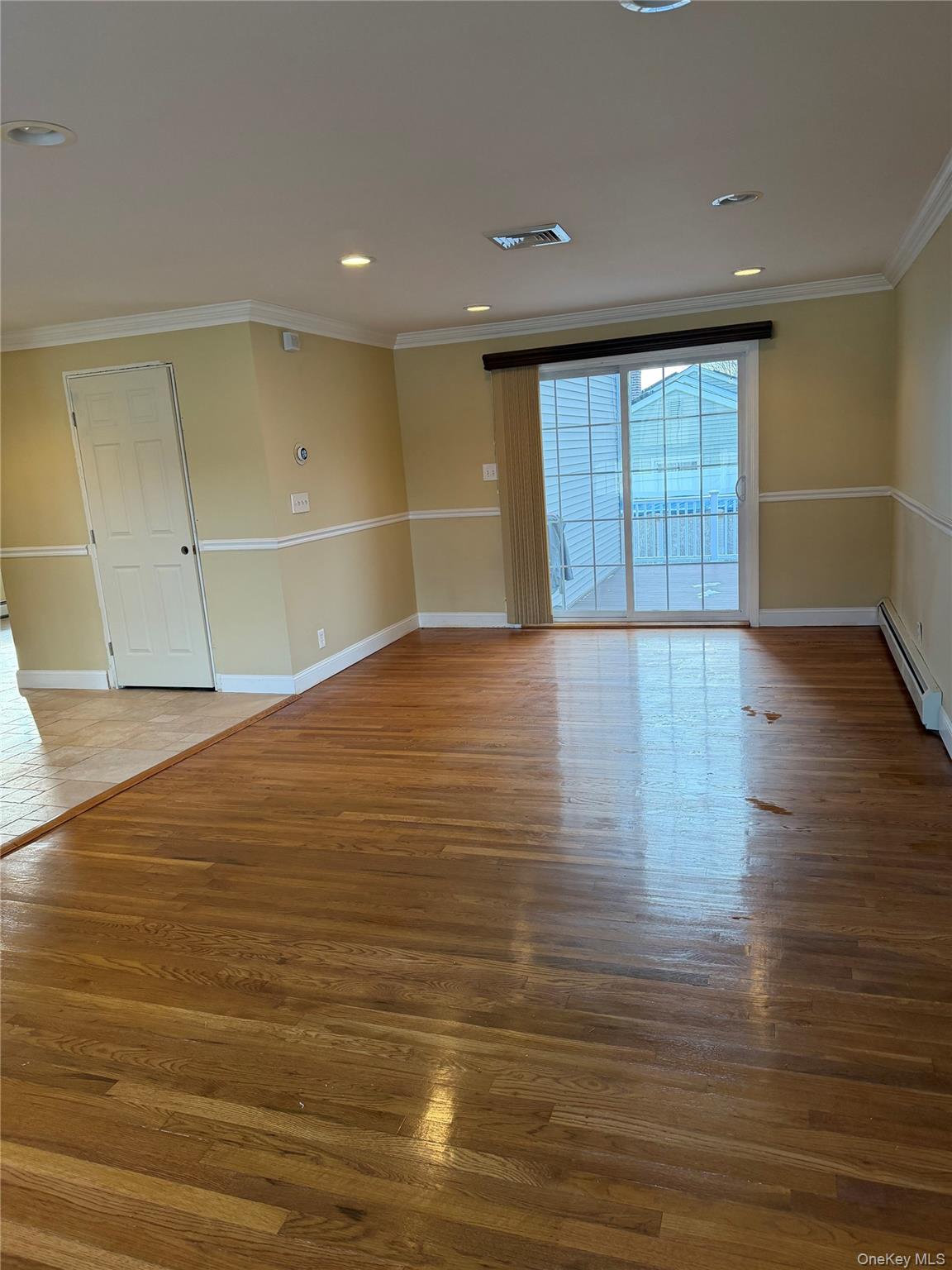 72 North Fordham Road Hicksville, NY 11801 - Photo 4 of 27 a view of an empty room with wooden floor and a window