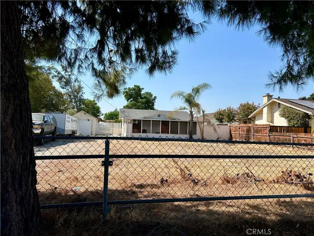 a view of a house with a yard and large tree
