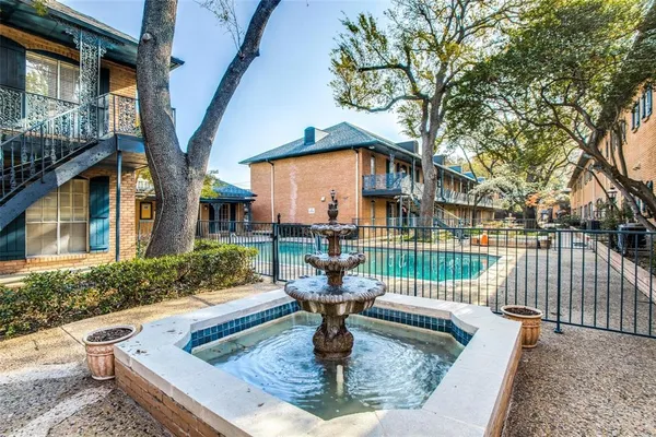 a view of a house with fountain in front of house