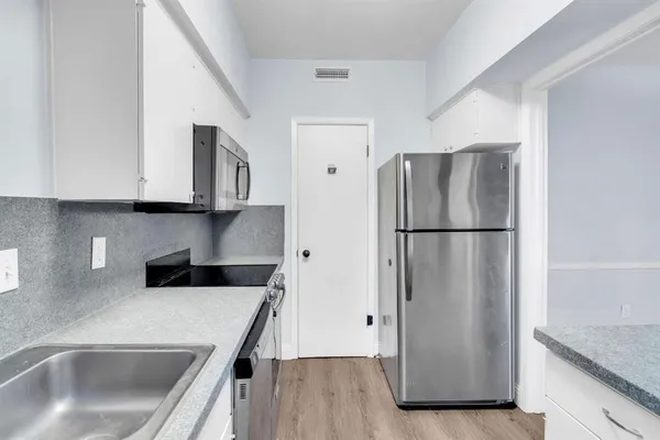 a kitchen with stainless steel appliances granite countertop a refrigerator a sink a stove and cabinets