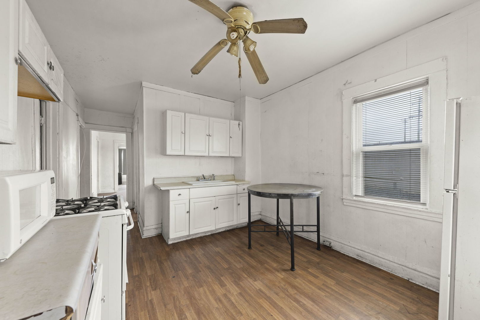 910 St Charles Road Maywood, IL 60153 - Photo 4 of 13 a kitchen with a refrigerator a stove cabinets and wooden floor