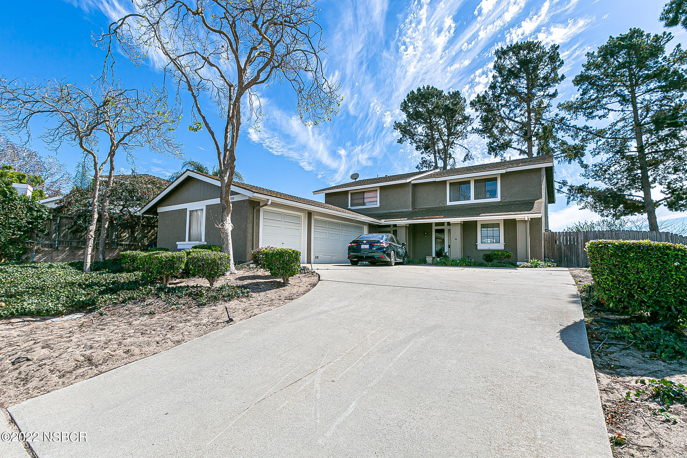 a front view of house with yard and trees in the background