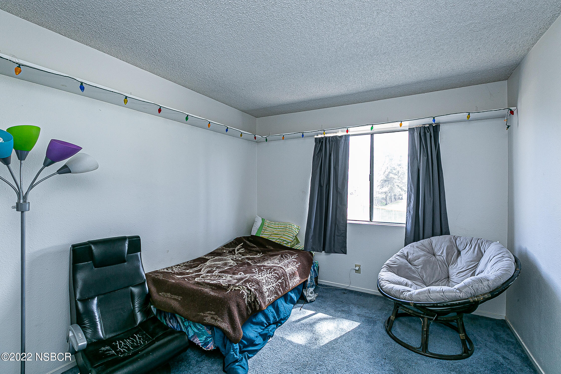 1210 East Foster Road, Unit B Santa Maria, CA 93455 - Photo 17 of 30 a bedroom with a bed and a chair