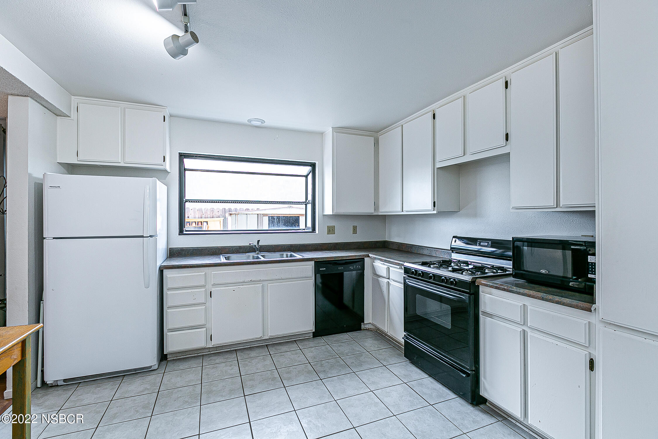 1210 East Foster Road, Unit B Santa Maria, CA 93455 - Photo 6 of 30 a kitchen with white cabinets and white appliances