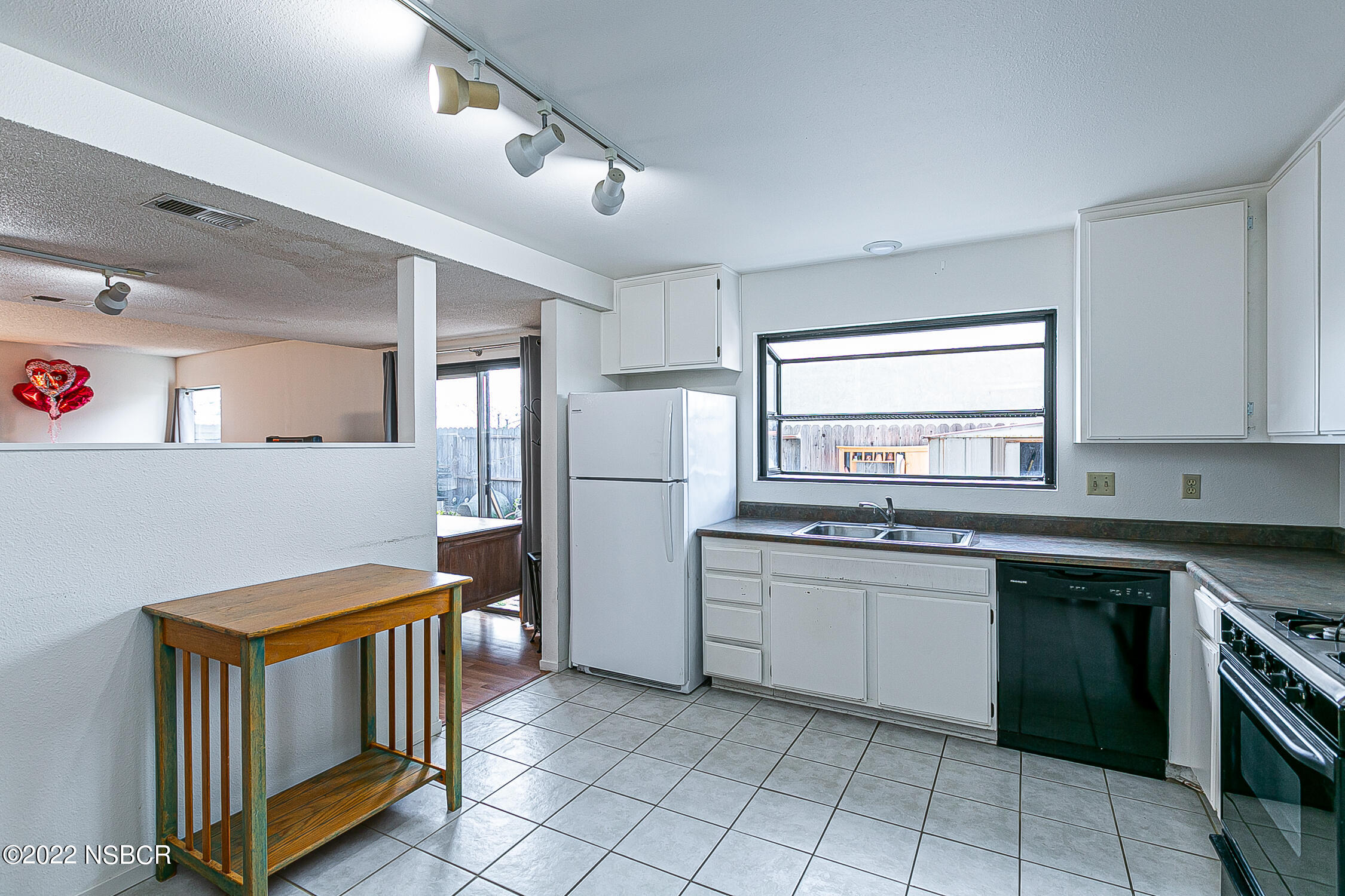 1210 East Foster Road, Unit B Santa Maria, CA 93455 - Photo 7 of 30 a kitchen with stainless steel appliances granite countertop a sink and dishwasher a refrigerator with wooden cabinets