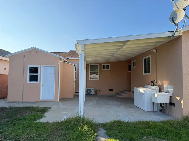 a view of a house with a small yard and sitting area