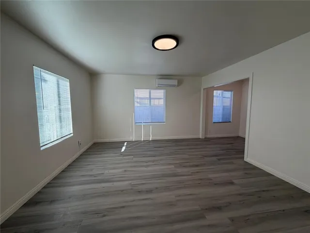 a view of empty room with window and wooden floor