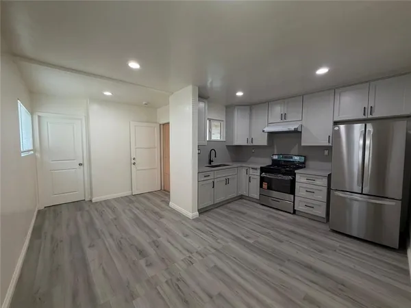a kitchen with stainless steel appliances a refrigerator sink and microwave