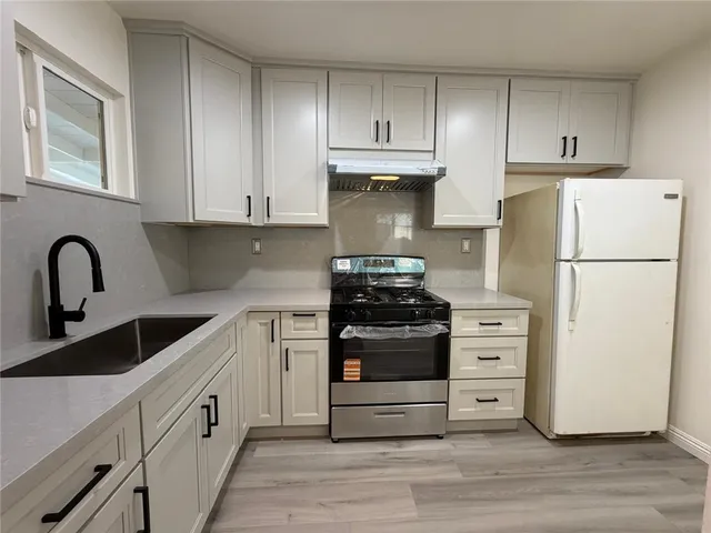 a kitchen with refrigerator a stove and a sink