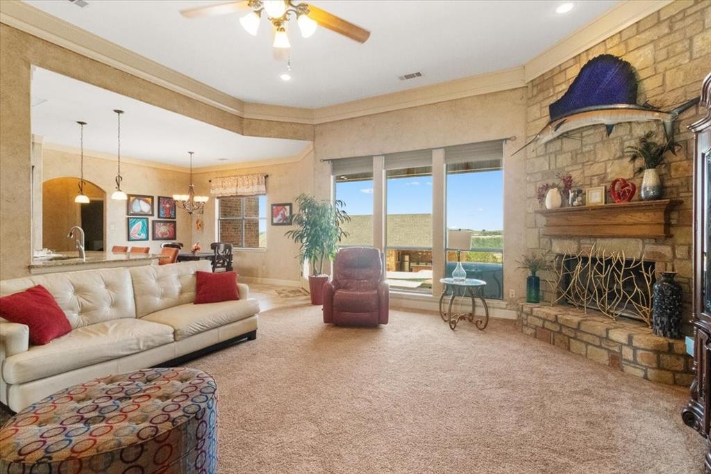 120 Trail Ridge Weatherford, TX 76087 - Photo 15 of 37 Living area with viewing of pool area and back yard, open to breakfast area. Textured ceilings throughout, ceiling fan, and fireplace