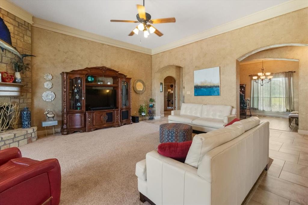 120 Trail Ridge Weatherford, TX 76087 - Photo 17 of 37 Living room featuring arched walkways, ceiling fan, stone fireplace