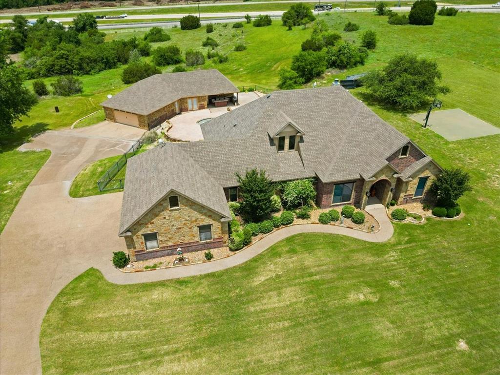 120 Trail Ridge Weatherford, TX 76087 - Photo 2 of 37 Aerial view of main house with 3 car side entry garage and drive past main house to 2 separate 2 car garage with pool house and attached outdoor kitchen.