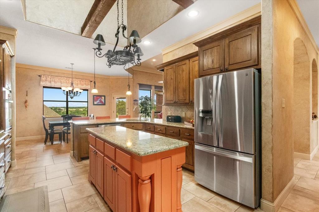 120 Trail Ridge Weatherford, TX 76087 - Photo 27 of 37 Kitchen with hanging pot and pan rack, island for additional food preparation, pot and pan drawers, oven, microwave, open to breakfast area