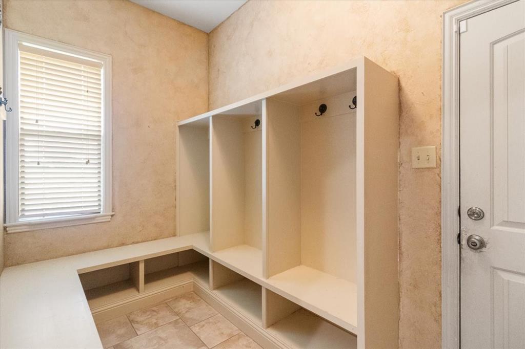 120 Trail Ridge Weatherford, TX 76087 - Photo 29 of 37 Mudroom accessing from garage to interior, featuring coat hooks, cubbies, seating and shelves, light tile patterned flooring