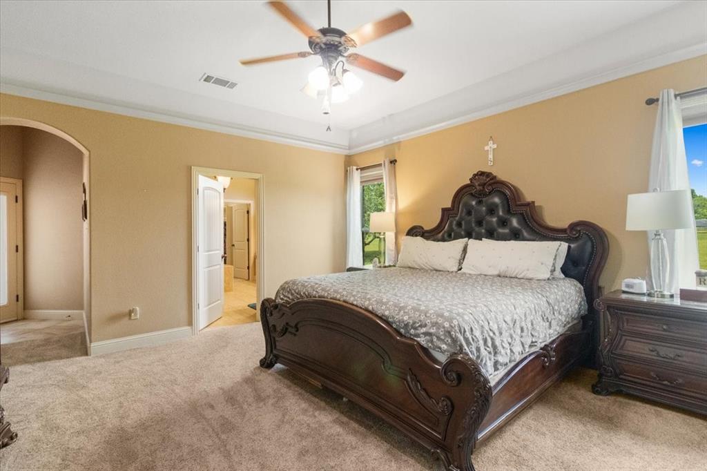 120 Trail Ridge Weatherford, TX 76087 - Photo 31 of 37 Oversized primary bedroom with private access to exterior and magnificent luxirious master bath and custom closet with abundance of storage, seasonal rods, drawers, shelves