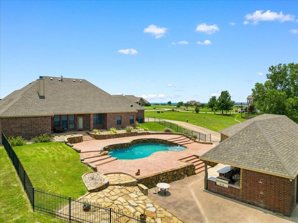 120 Trail Ridge Weatherford, TX 76087 - Photo 4 of 37 View of swimming pool nestled between the main house and the pool house and convenience to outdoor kitchen and bar and climate contolled pool house with full bath. There is an outdoor shower for conveniene as well.