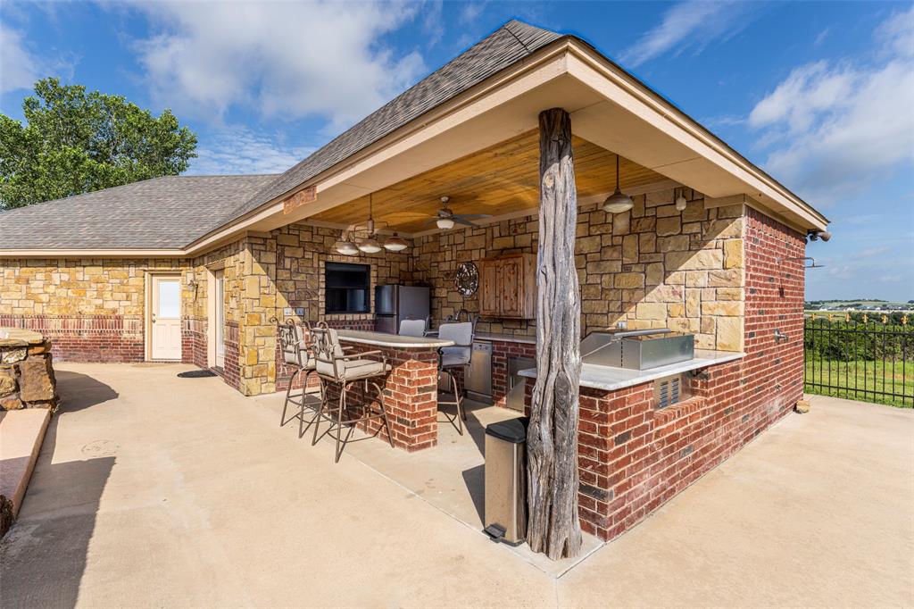 120 Trail Ridge Weatherford, TX 76087 - Photo 9 of 37 Pool house w Outdoor kitchen with ceiling fan, bar