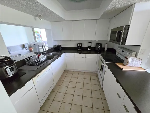 a large kitchen with a sink and cabinets