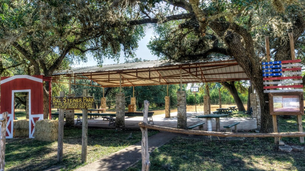 533 Squirrel Bend Uvalde, TX 78801 - Photo 18 of 19 a view of a patio with table and chairs under an umbrella with large trees