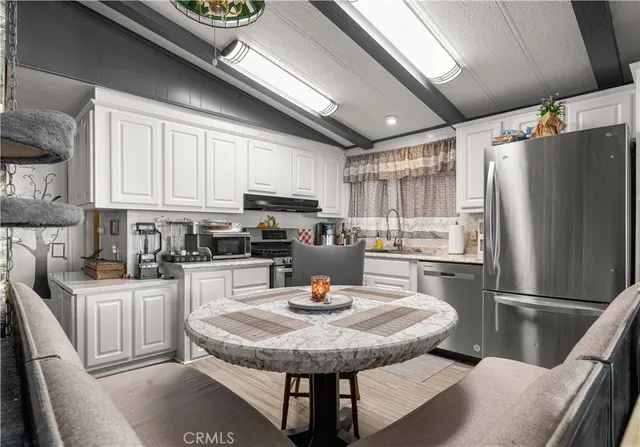 a kitchen with a table chairs and refrigerator