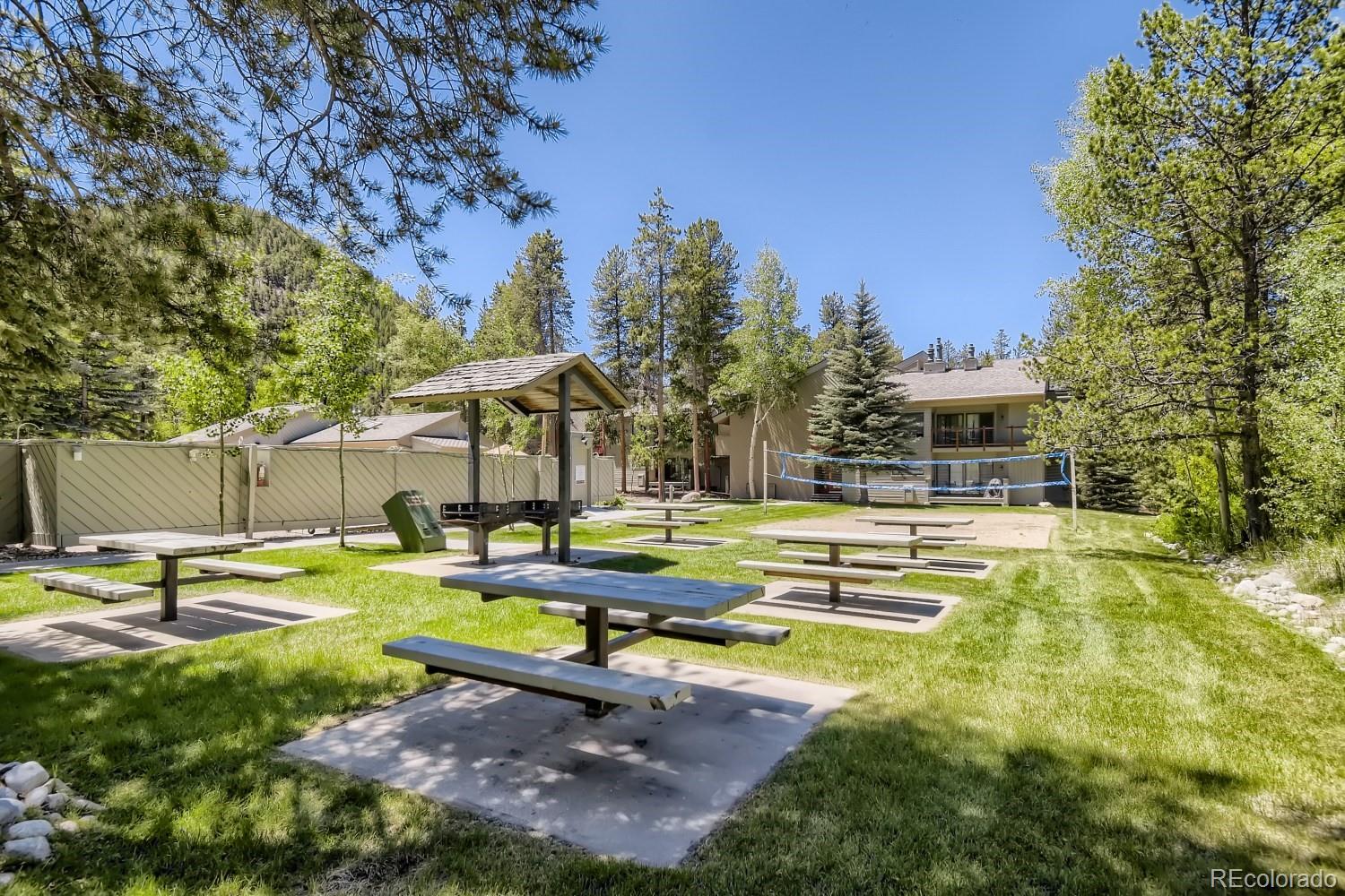 1937 Soda Ridge Road, Unit 1153/1154 Dillon, CO 80435 - Photo 16 of 17 a view of pool with lawn chairs and large trees