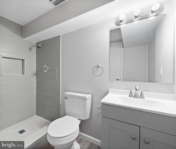 a bathroom with a toilet a sink a mirror and vanity