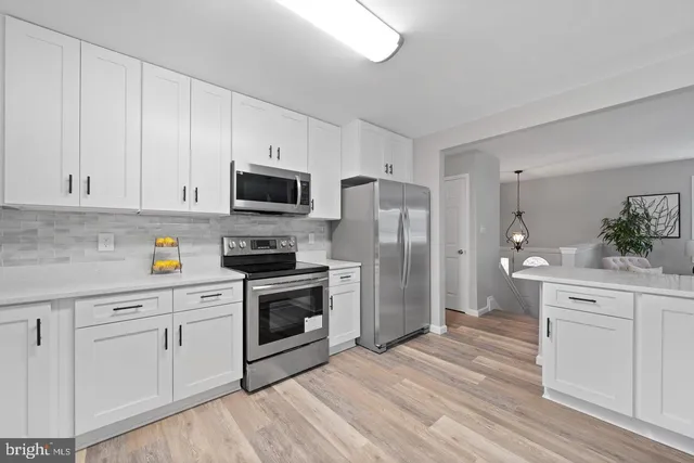 a kitchen with white cabinets and stainless steel appliances