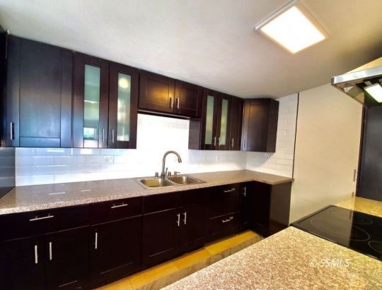 1512 South Mahan Street Ridgecrest, CA 93555 - Photo 7 of 16 a kitchen with a sink and a wooden cabinets