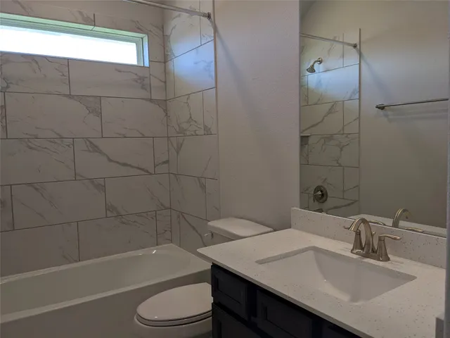 a bathroom with a sink toilet vanity and bathtub