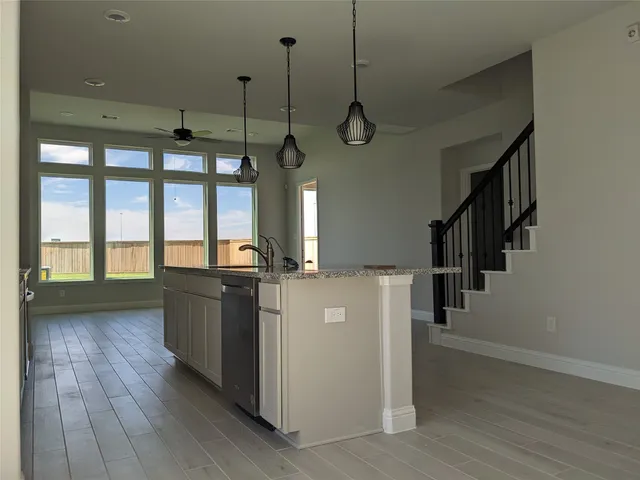 a kitchen with kitchen island wooden floor center island stainless steel appliances and wooden floor
