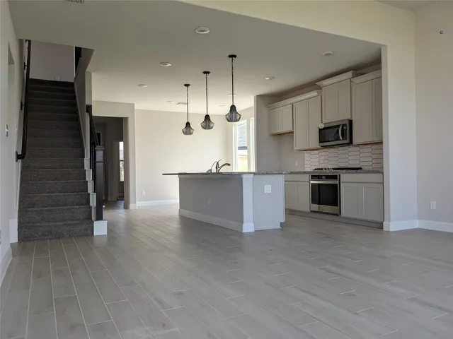 a large kitchen with stainless steel appliances granite countertop a stove and a refrigerator